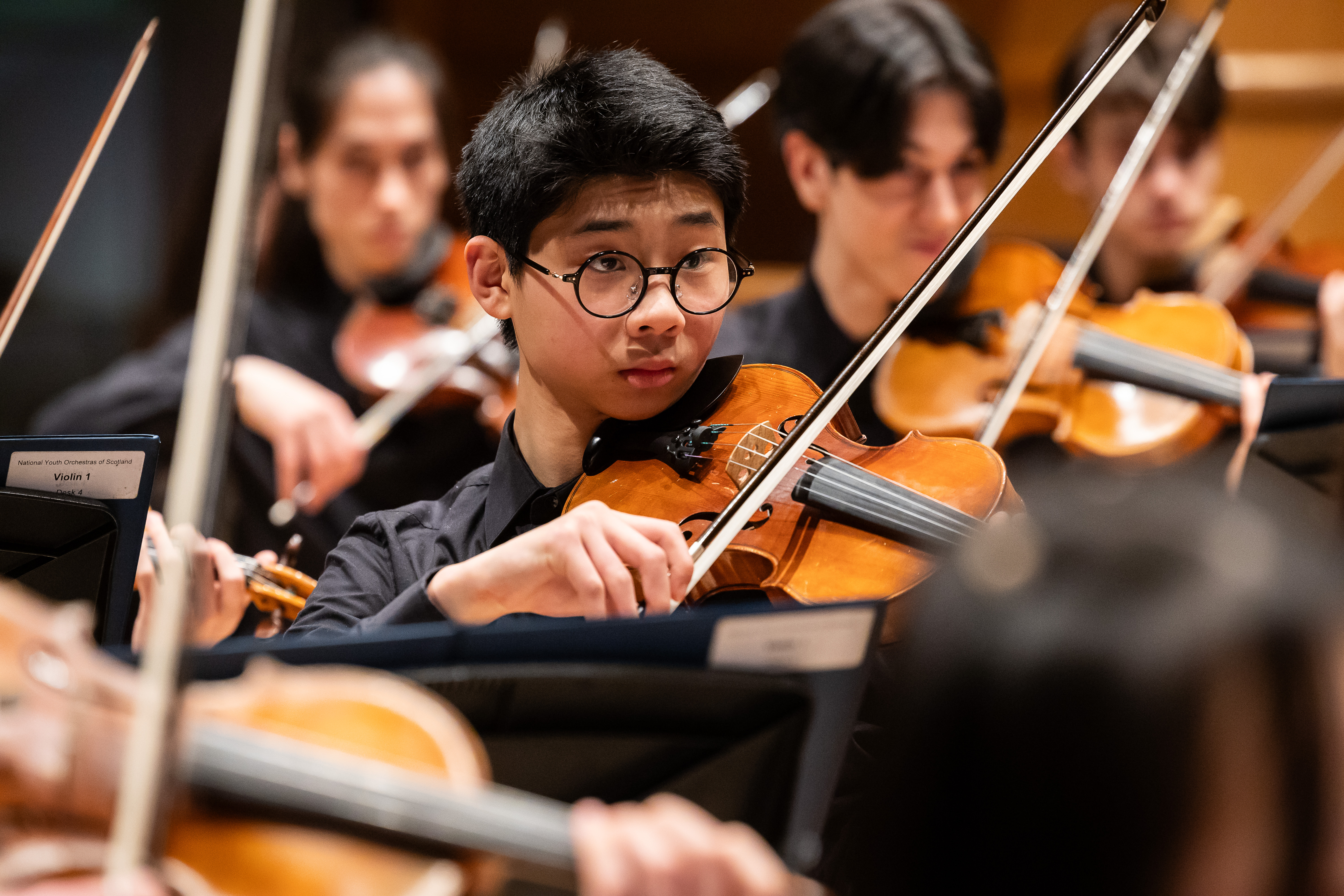 Violin player in the National Youth Orchestra of Scotland prepares to perform